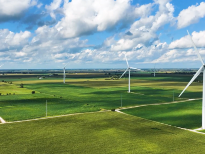 A green field in rural America with wind turbines
