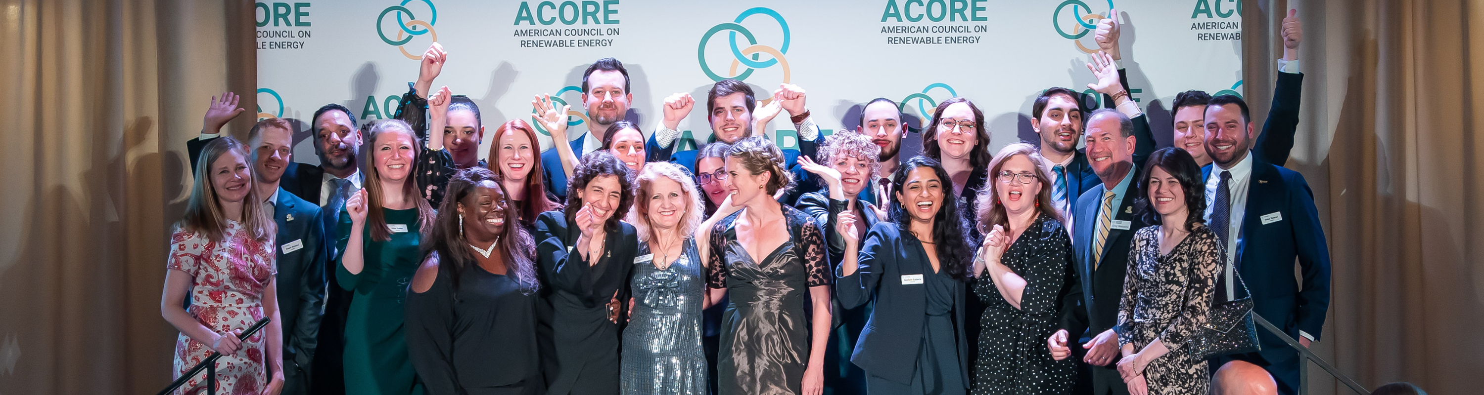 Members of ACORE's team laugh and pose on the stage during the ACORE Gala