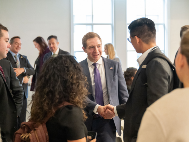 Attendees network and shake hands with keynote speaker Alex Fitzsimmons.