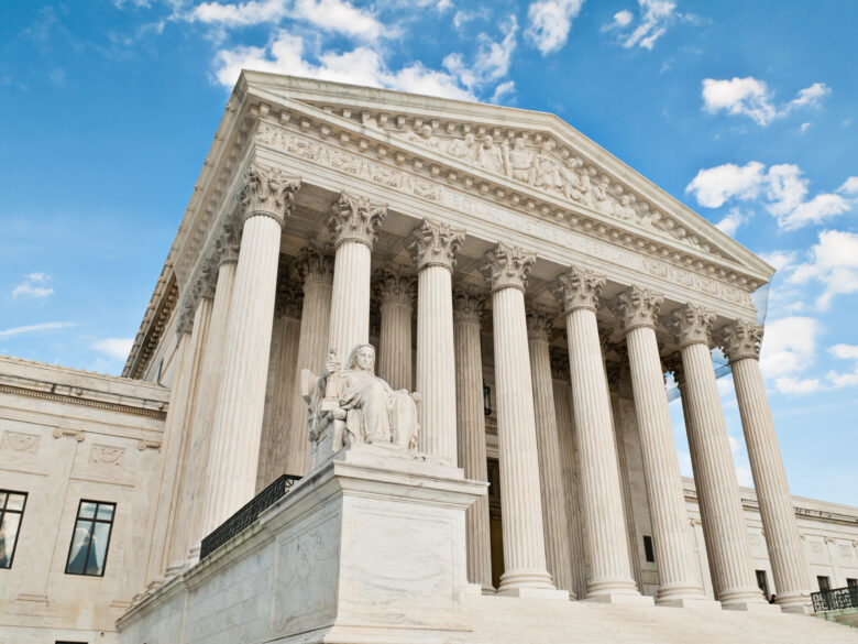 The United States Supreme Court building in Washington DC. against a blue sky