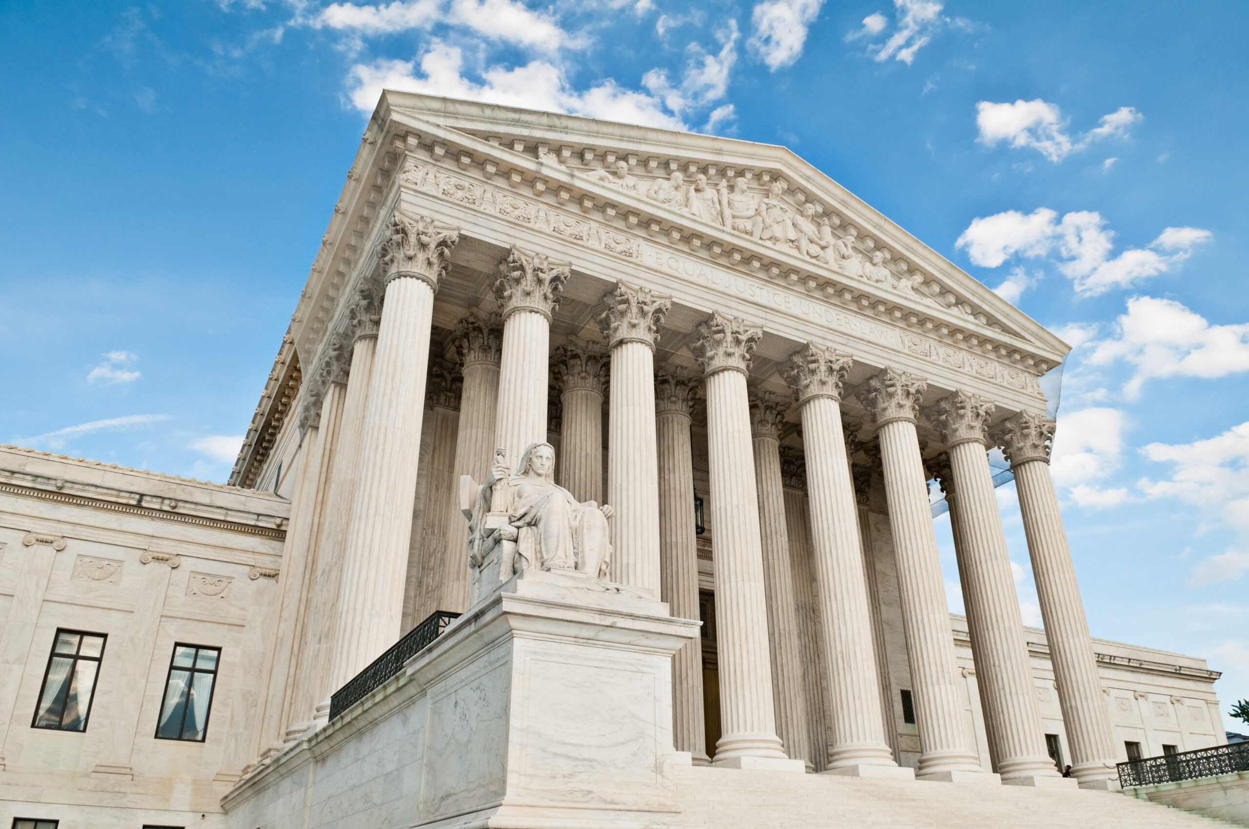 The United States Supreme Court building in Washington DC. against a blue sky