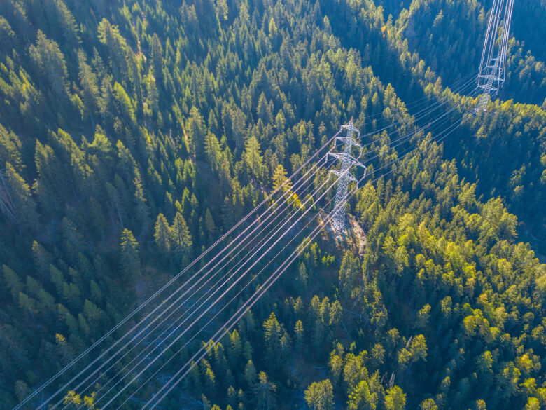 Aerial view of power line pylon in mountainous area in Switzerland
