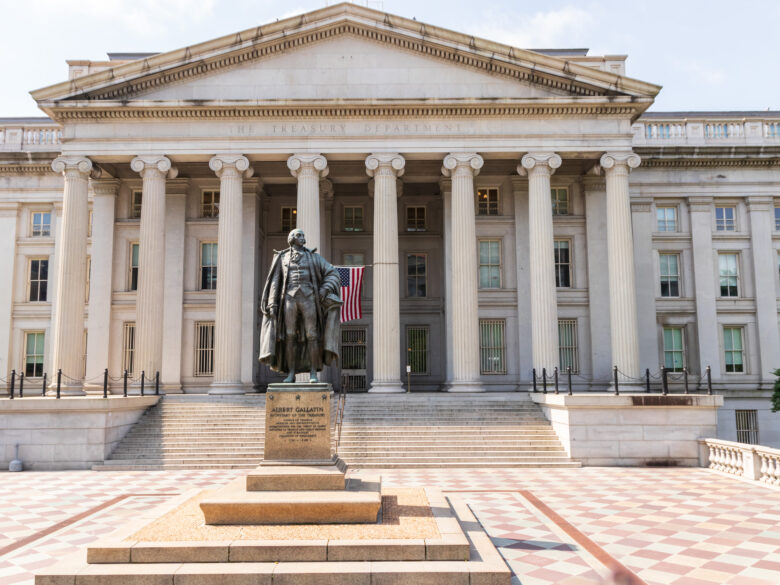 U.S. Treasury building with ornate white columns and a statue of Alexander Hamilton out front