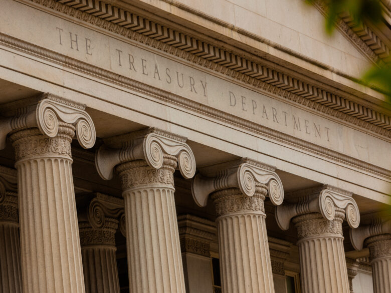 Exterior of US Treasury building with columns and text reading "The Treasury Department"