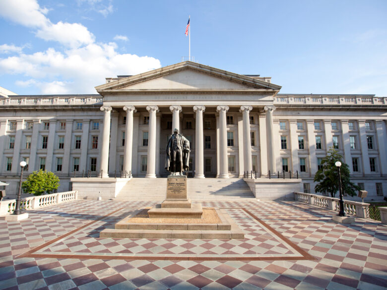 U.S. Treasury building with ornate white columns and a statue of Alexander Hamilton out front