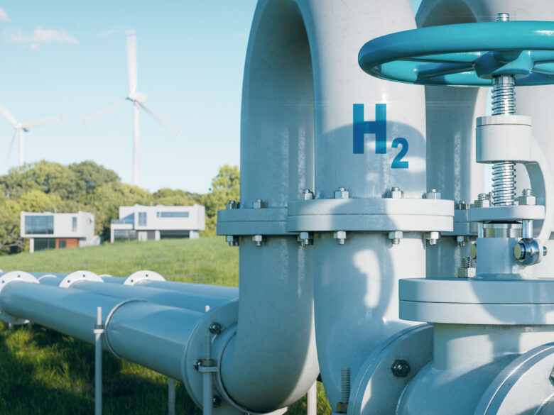 A hydrogen pipeline to houses with wind turbines in the background