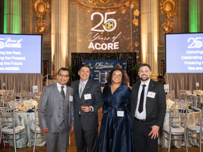 Four attendees post for a photo at the Mellon Auditorium.