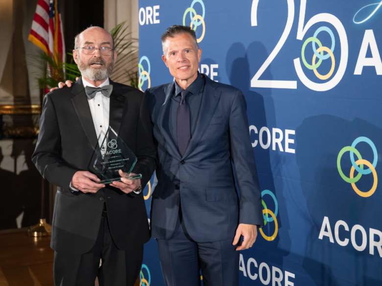 Ray Long and Michael Eckhart pose for a photo on stage as Mike received the Lifetime Achievement Award.