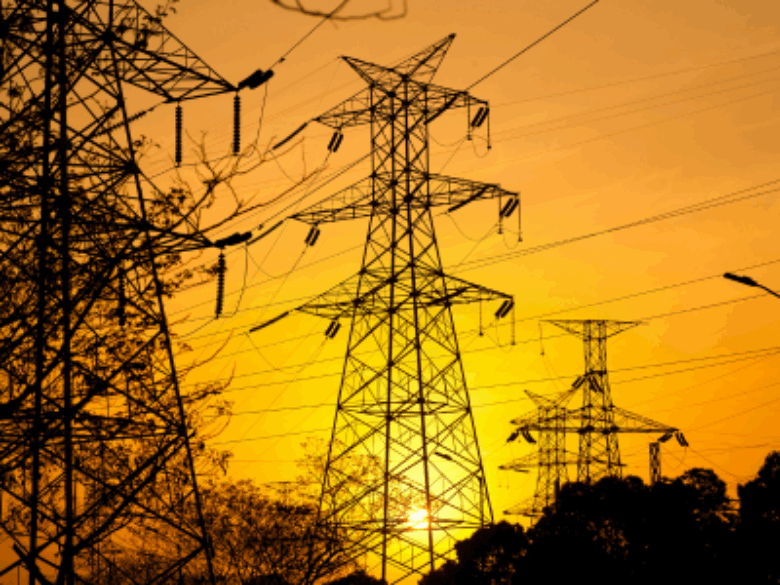 Transmission towers with yellow sky in the background.