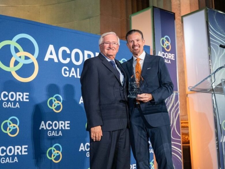 Ray Long and Kevin Gresham smile on stage with an award at the 2025 ACORE Gala.