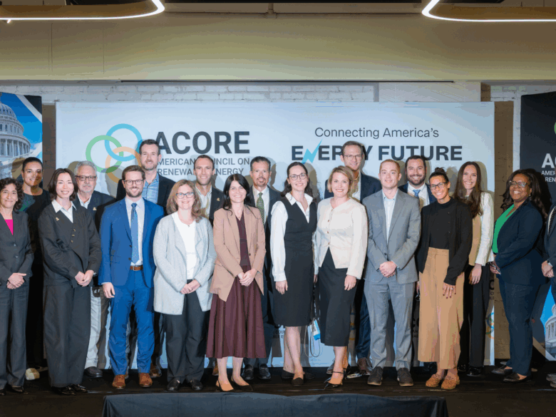 Photo of ACORE Team members standing on stage smiling.