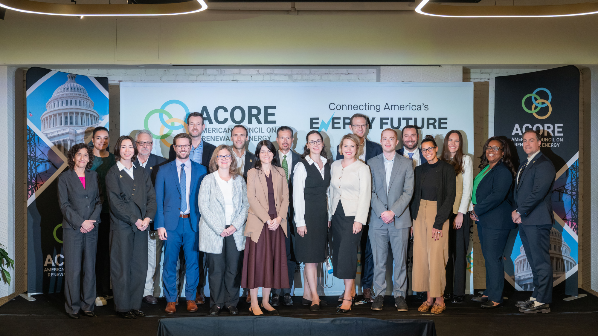 Photo of ACORE Team members standing on stage smiling.