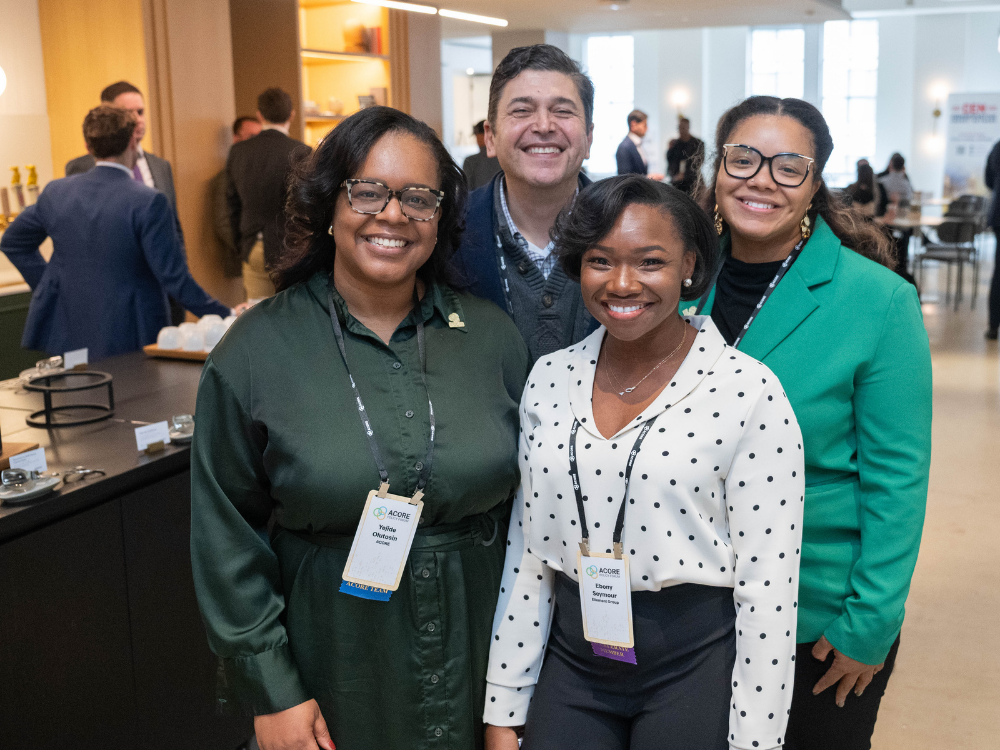 Four event attendees smiling during a networking break.
