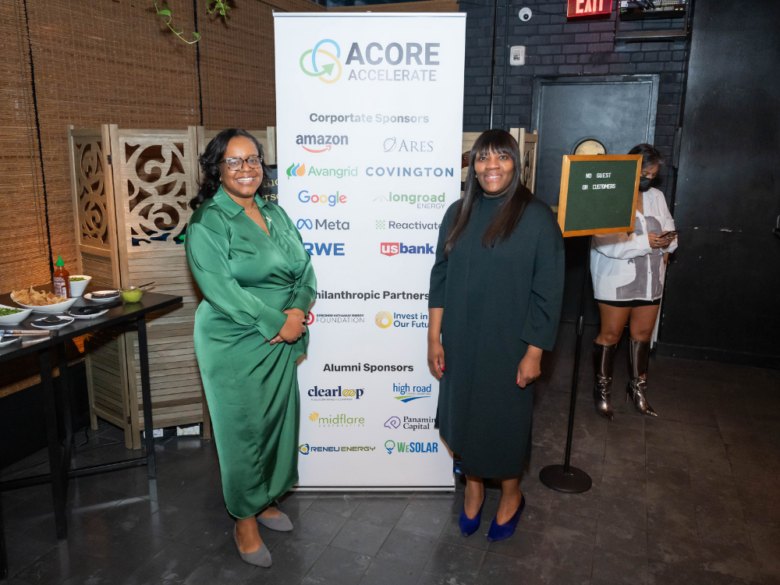 Attendees pose in front of the ACORE Accelerate sponsor sign.