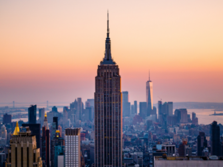 New York City skyline with sunset in background.