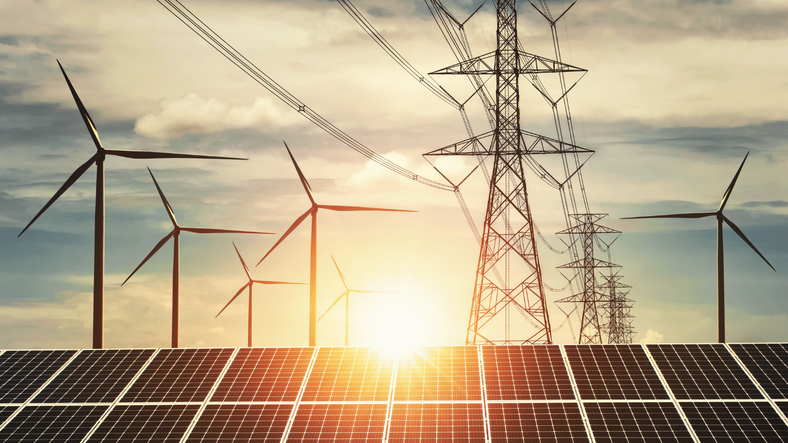 Solar panels, wind turbines, and transmission lines at sunset.
