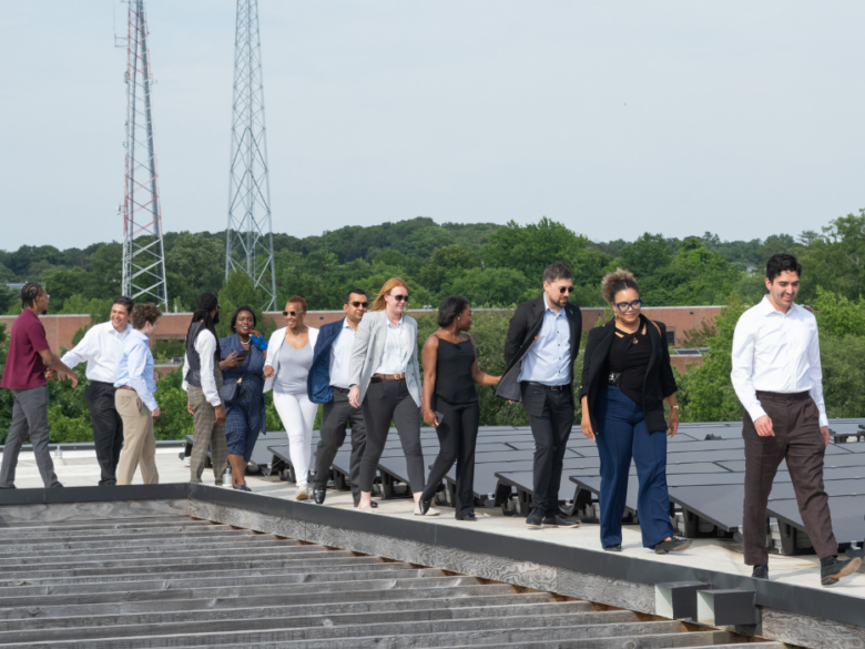 ACORE Accelerate visit to Sycamore & Oak. The group walks on the roof in from of solar panels.