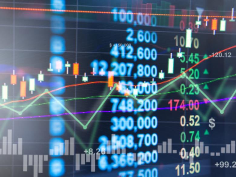 Close-up of a digital financial market display showing stock price charts, candlestick graphs, trend lines, trading volume bars, and numerical data overlaid on a dark background. Green and red indicators reflect market movement, while blue and white figures display trading values and performance metrics.