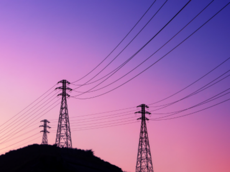 Transmission towers with a pink and purple sky.