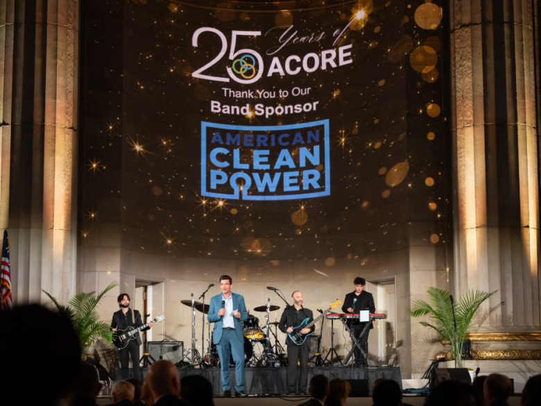 Live band performing during ACORE’s 25th Anniversary Gala, with American Clean Power recognized as the band sponsor on the projection above the stage.