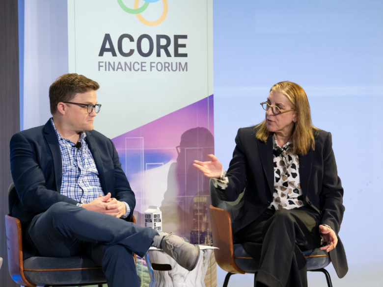 Two speakers in conversation onstage during the ACORE Finance Forum.