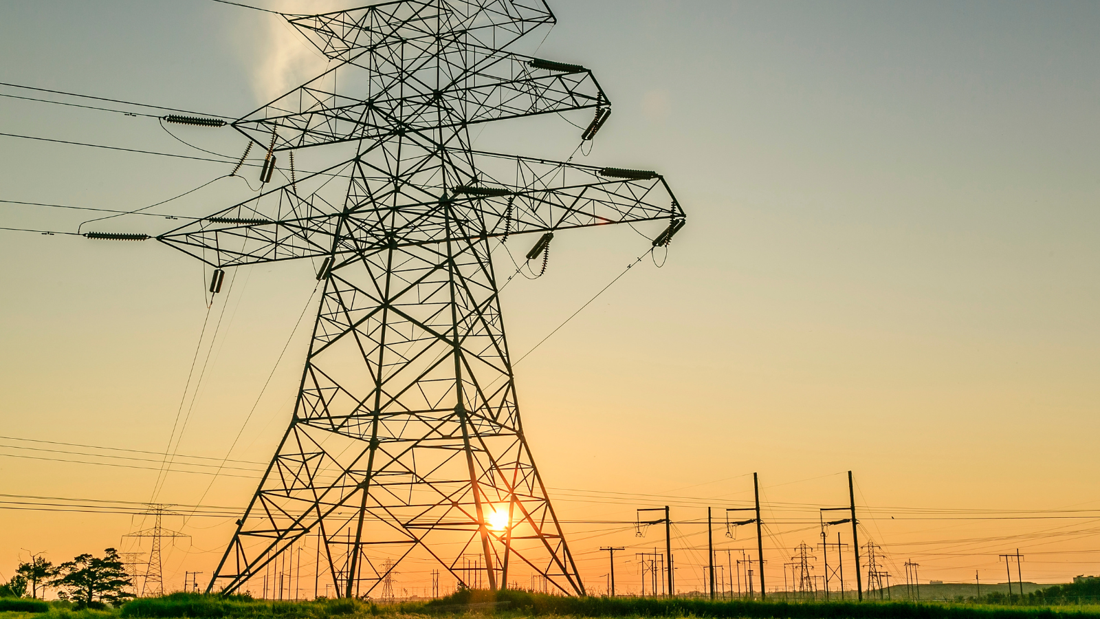 Transmission lines with a sunset in the background.