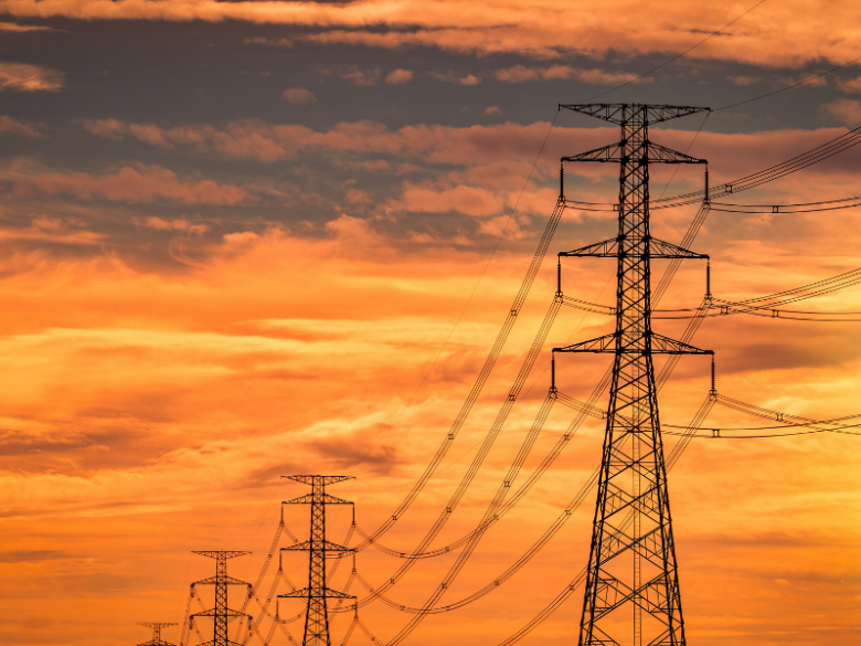 Transmission towers with a golden sunset in the background.